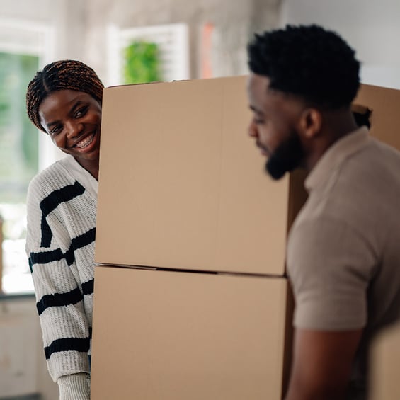 couple-moving-large-box-into-new-home