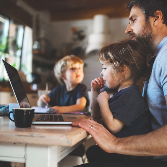 man-with-children-working-from-laptop-in-kitchen
