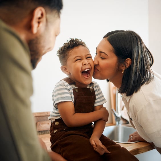 mom-kisses-happy-son-on-kitchen-counter